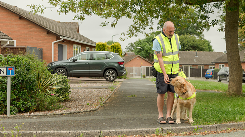Guide dog owner standing by road with guide dog
