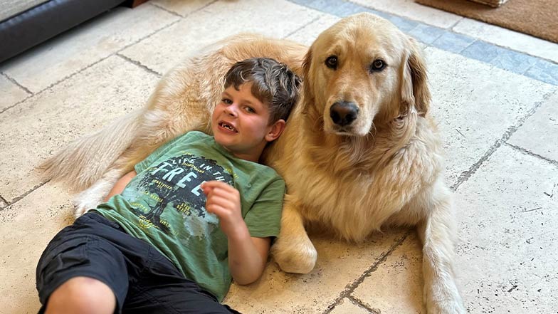Alex and Chance, his buddy dog, cuddle on the floor together.