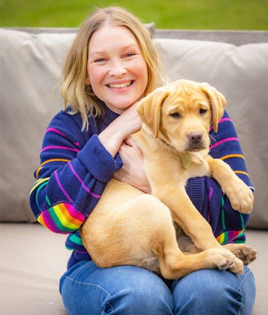 The real Flash puppy sits on the lap of Joanna Page