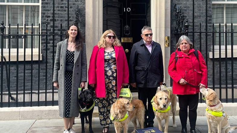 Campaigners stand outside number 10 downing street with guide dogs