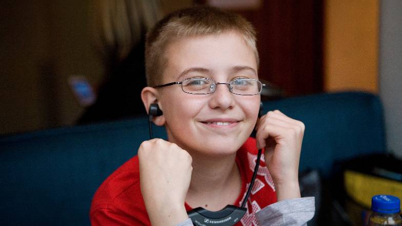 A young boy with sight loss listening to a story through head phones
