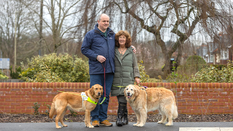 Two guide dog owners walking their guide dogs 
