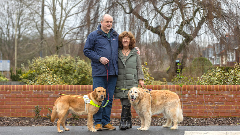 Two guide dog owners walking their guide dogs