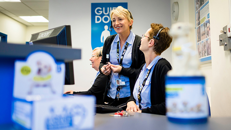Two Guide Dogs members of staff talking
