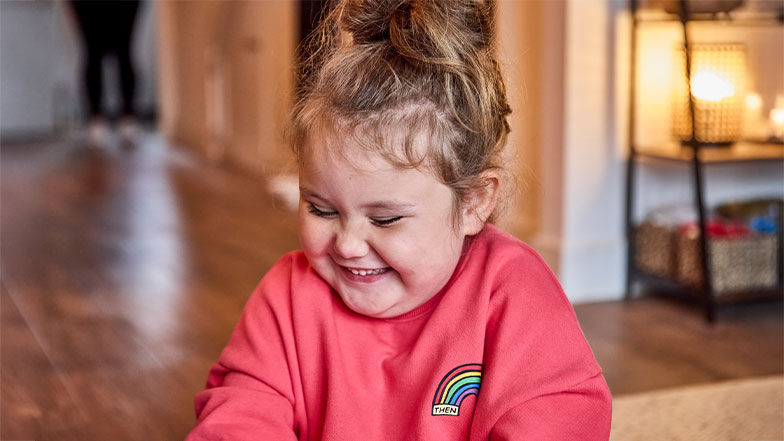 A four year old Mable diagnosed with optic nerve hyperplasia, smiles as she explores some sensory toys at home.