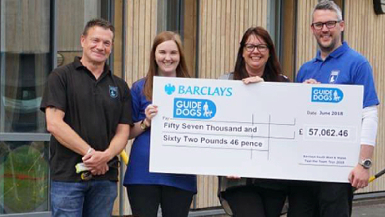 Four Guide Dogs representatives hold a cheque from Barclays for £57,062