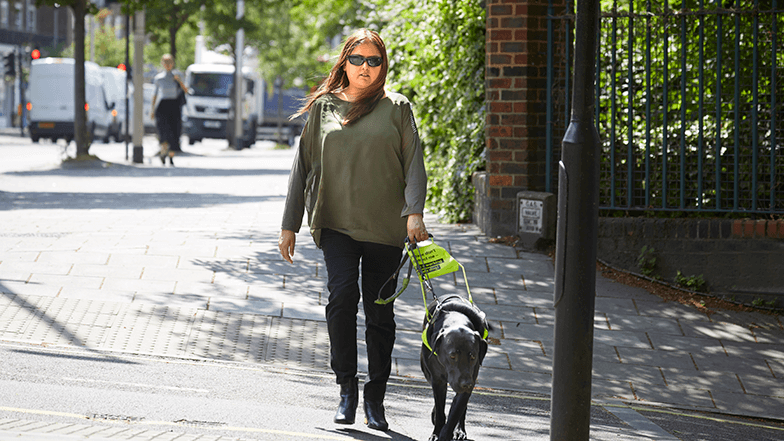 Guide dog owner Bhavini crossing the road with guide dog Colin