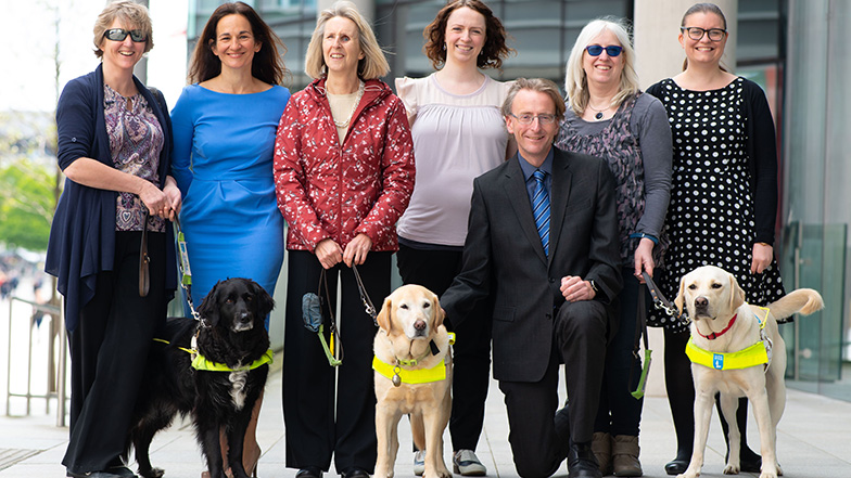 Blake Morgan LLP team standing with three guide dog owners and their dogs