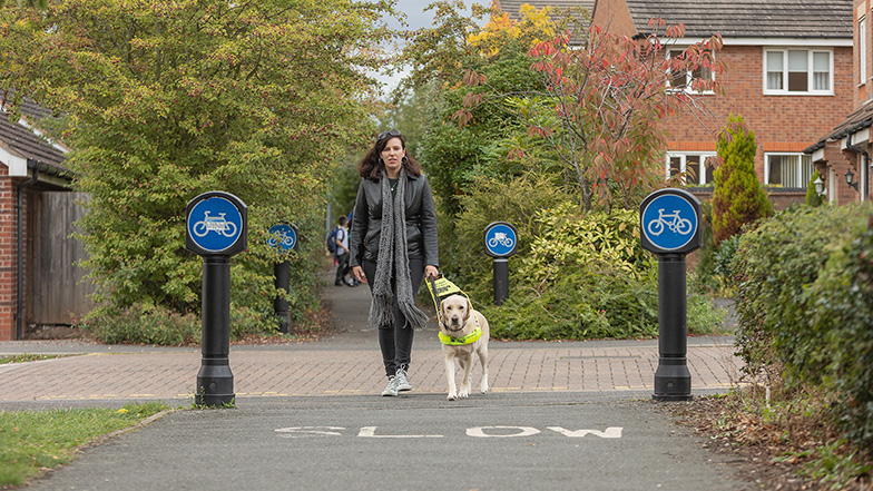 Guide dog owner Alice walking through a housing estate with guide dog Dora