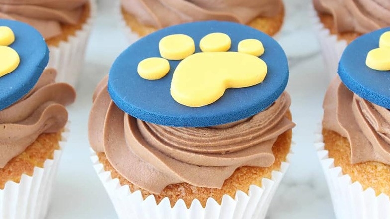 A cupcake with a Guide Dogs pawprint logo on the top