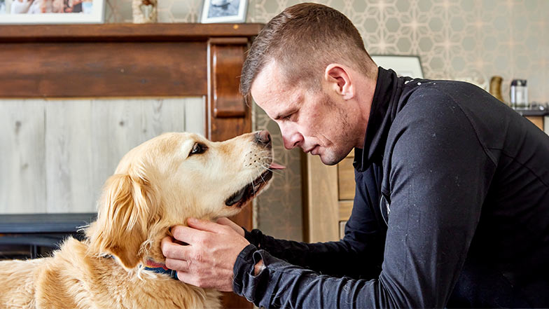 Guide dog owner Scott and guide dog Milo looking adoringly at each other 