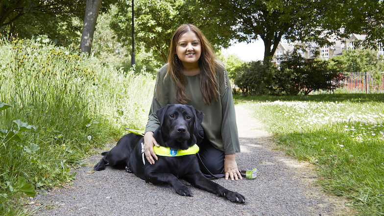 Guide dog owner sat down on a path with guide dog Colin