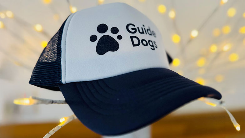 A Guide Dogs branded cap in navy and white