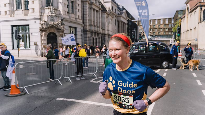 A runner in the London Landmarks Half Marathon in a Guide Dogs T-shirt