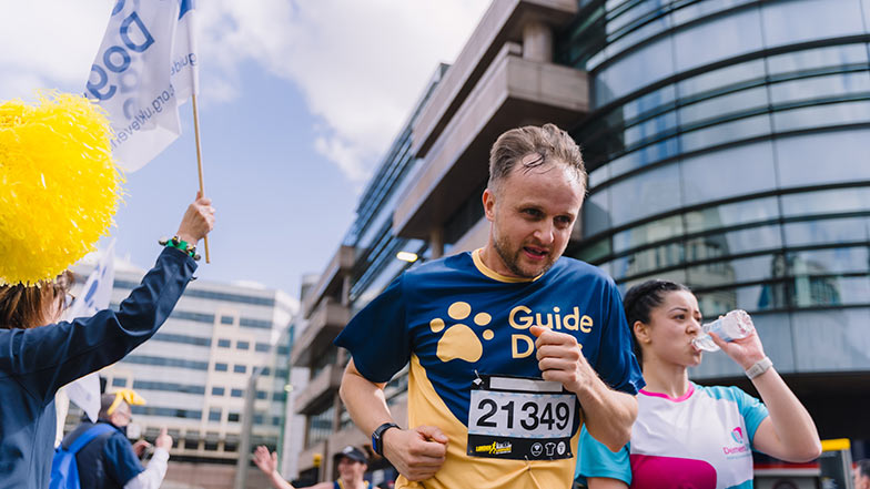 A runner in the London Landmarks Half Marathon in a Guide Dogs T-shirt