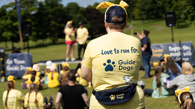 Person in Guide Dogs t-shirt saying 'love to run for Guide Dogs' with dog ears 
