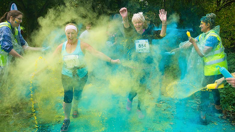 Women running through coloured powder