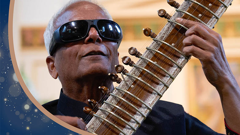 a member of the Inner Vision Orchestra playing a sitar