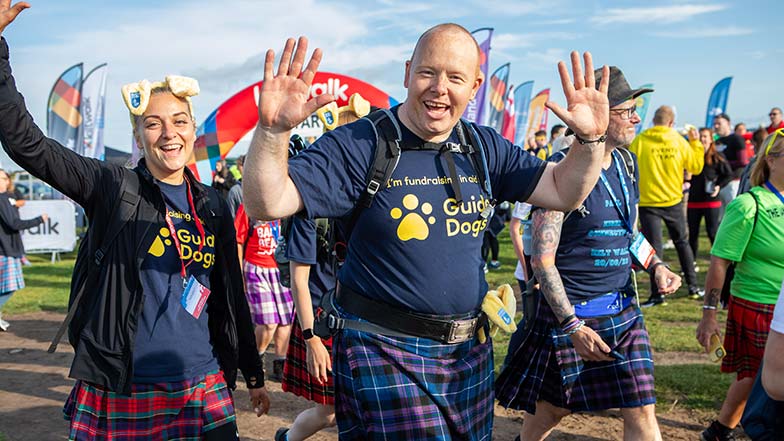 People pictured smiling wearing Dogs fundraising t-shirts walking a Kiltwalk route.