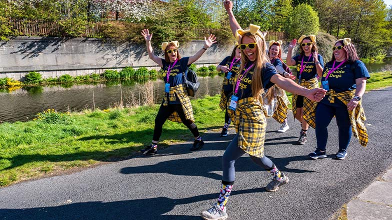 People on a Kiltwalk wearing Guide Dogs t-shirts, branded socks and dog ears 