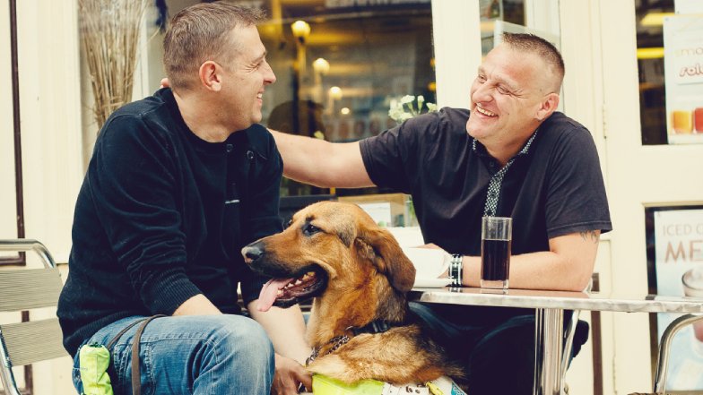 Steve Bowles with his guide dog and a friend at a cafe
