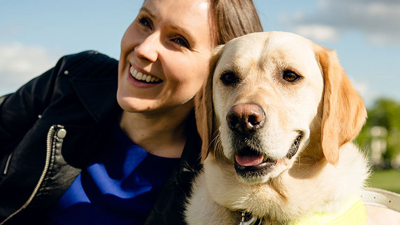 Guide dog and owner sitting together in a park Guide dog and owner sitting together in a park