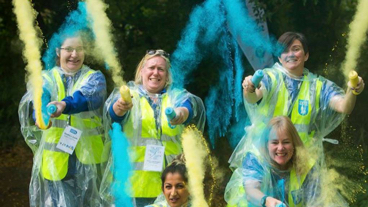 Guide dogs volunteers throwing powdered paint into the air
