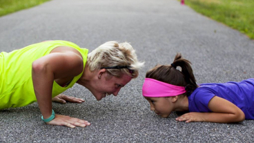 A woman and child doing press ups facing one another