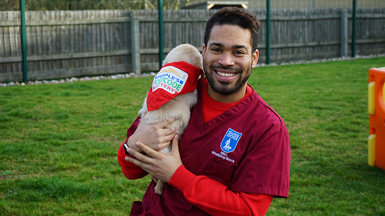 People's Postcode Lottery Presenter Danyl Johnson holding player-funded puppy Ziggy