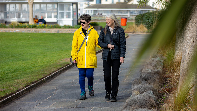 A person with sight loss being guided in a park