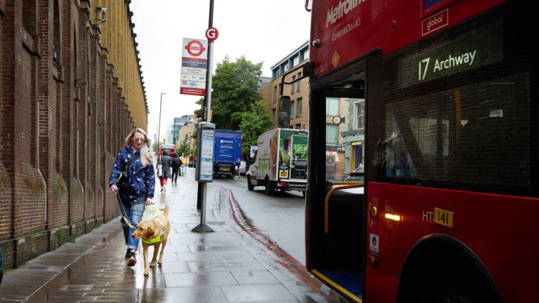 Emma and guide dog Archie getting on a bus
