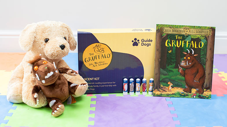 Guide Dogs Gruffalo scent kit sitting alongside a guide dog soft toy and Gruffalo book