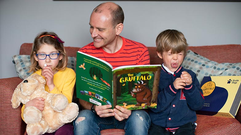 Father and his 2 children testing out the scent kits with the Gruffalo book 
