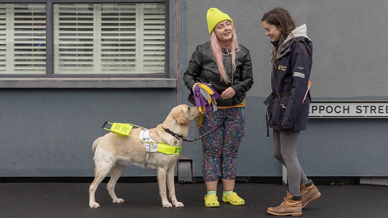 A guide dog owner and their guide dog are greeted by a Guide Dog Mobility Specialist.