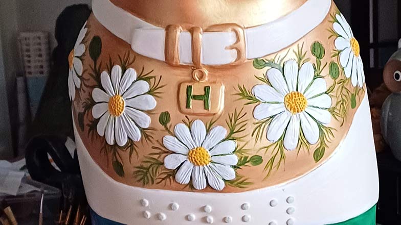 Close up of a decorated guide dog sculpture chest painted with a white daisy flower design