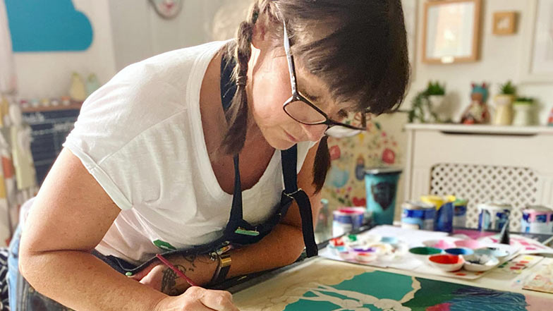 Artist Marnie Maurri in her art studio working on a painting