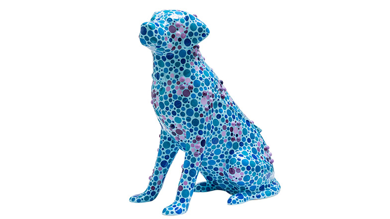 A blue guide dog sculpture with purple and blue spots. Some of the spots are raised, forming letters from the Braille alphabet.