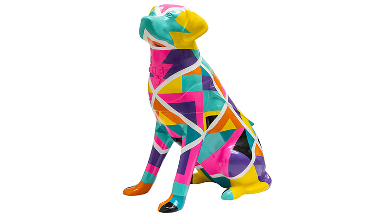 A guide dog sculpture covered with a colourful and vibrant geometric design.