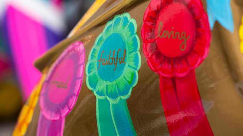Close up of some of the rosettes on the sculpture's side that show the words 'friend', 'faithful' and 'loving'.