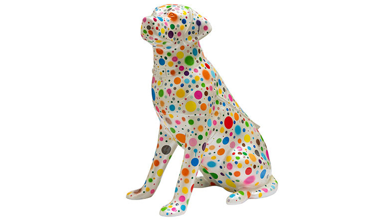 A guide dog sculpture with brightly coloured dots on a pale background.