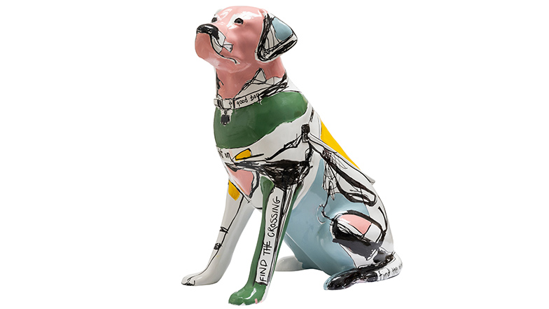 A green, grey and pink guide dog sculpture with 'straight on' written across its harness.