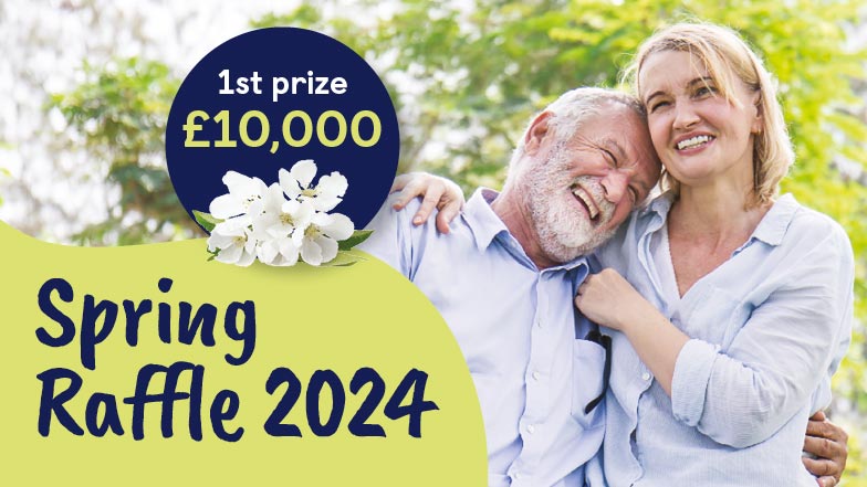 A smiling couple in each others arms, text on image reads 'Spring Raffle 2024 1st prize £10,000'