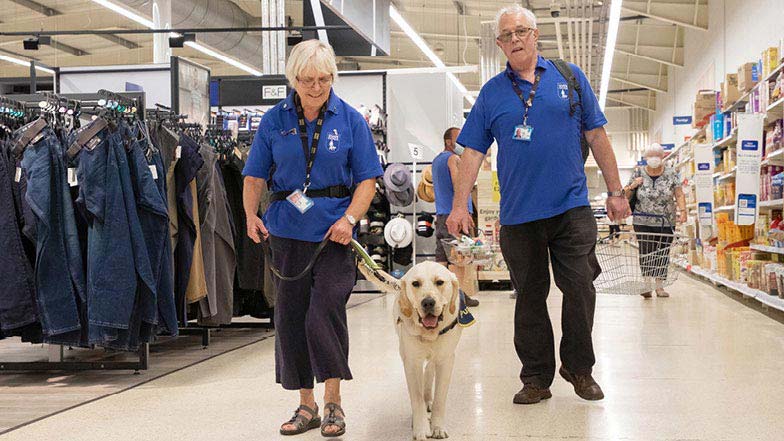 Murphy and his Puppy Raisers walking in the supermarket