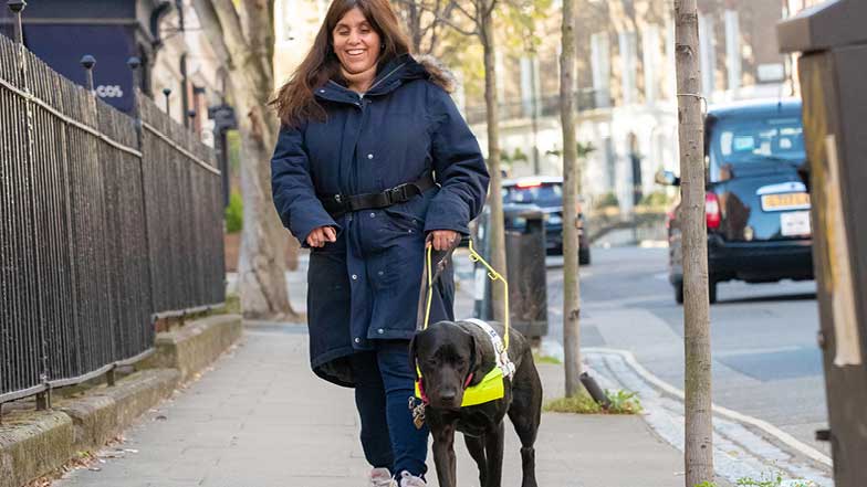 Rosie and her guide dog owner walking on a footpath
