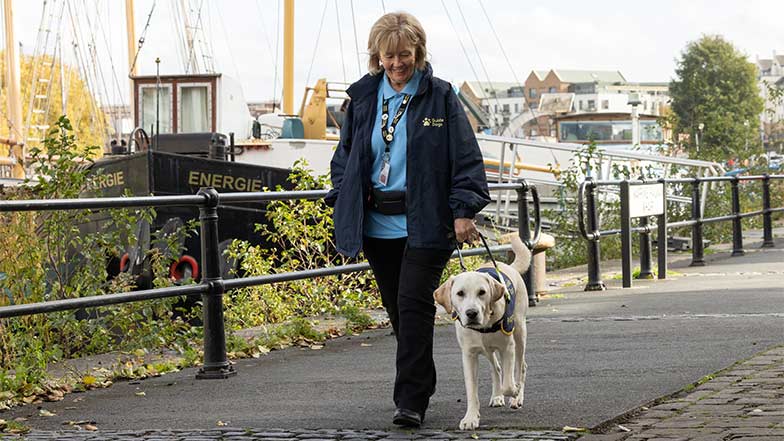 Rupert and Puppy Raiser Jean walking along a footpath