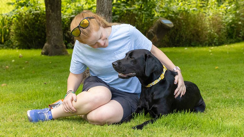 Black Labrador Sage lying beside Victoria on the grass Black Labrador Sage lying beside Victoria on the grass