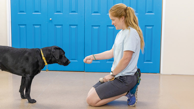 Sage standing in front of Victoria who is holding out her fist towards Sage