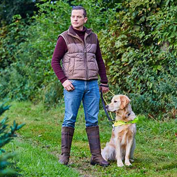 Scott and Milo standing together in a forest