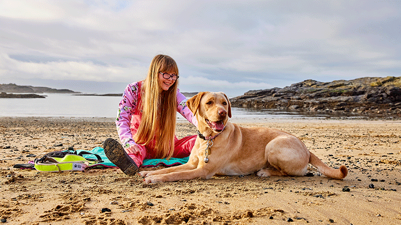 Angharad with her guide dog Sarah enjoying a day at the beach.