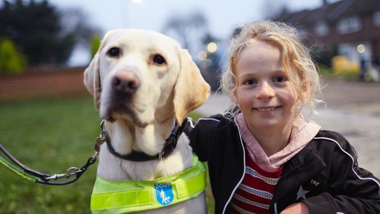 By My Side still image with Guide Dog and Guide Dog owner's daughter sitting next to each other smiling